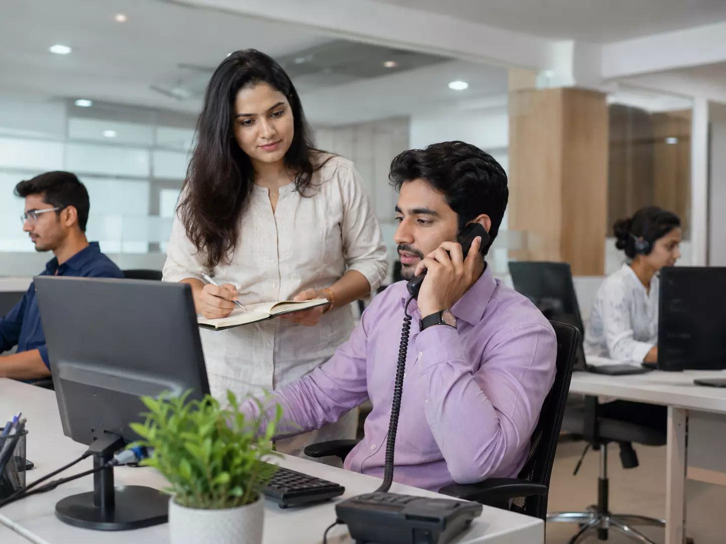 Indian business team collaborating around a laptop in an office
